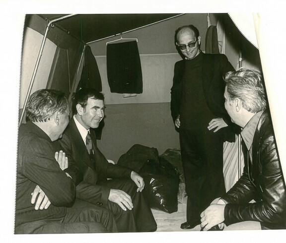 Mehrere Personen sitzen und stehen in einem Notzelt, sprechen miteinander und organisieren Hilfe nach dem Erdbeben in Friaul.