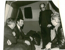 Mehrere Personen sitzen und stehen in einem Notzelt, sprechen miteinander und organisieren Hilfe nach dem Erdbeben in Friaul.