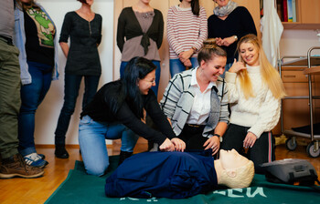 Studierende der SOB üben Reanimation an einer Pflegepuppe
