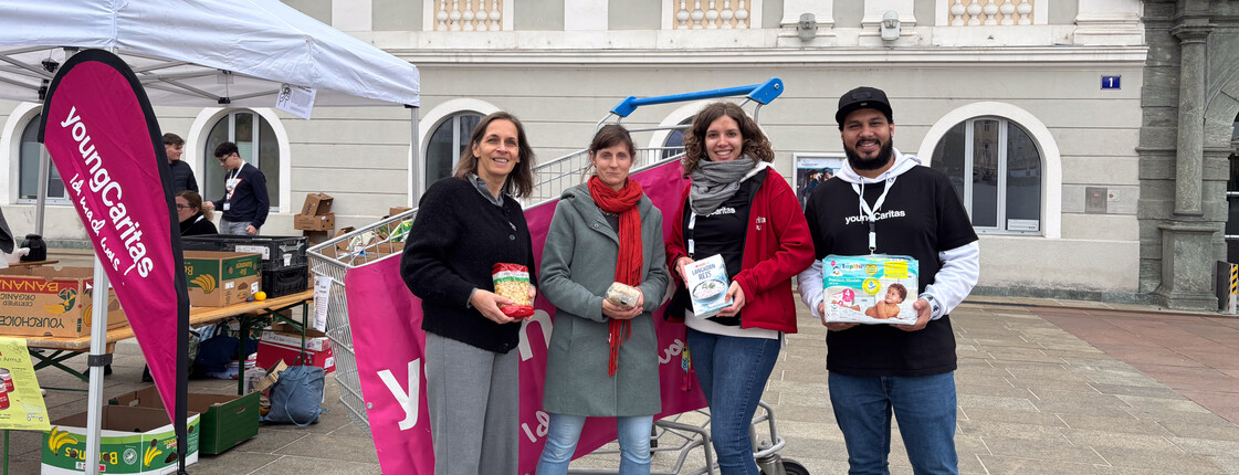 Marion Auer-Fercher, kaufmännische Geschäftsführerin der Caritas Kärnten und youngCaritas-Mitarbeiter*innen präsentieren Lebensmittel- und Hygieneartikel bei der youngCaritas-Sammelaktion am Neuen Platz in Klagenfurt.
