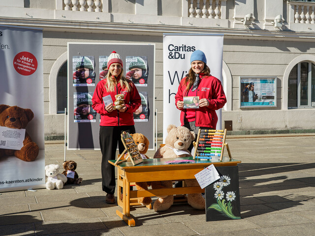 Zwei Frauen präsentieren Infomaterial vor Bäreninstallation zur Frühförderung am Neuen Platz.