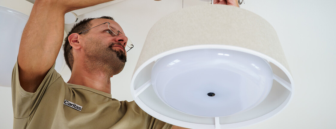 Haustechniker montiert smarte Nobi-Deckenlampe zur Sturzprävention im Haus Martha