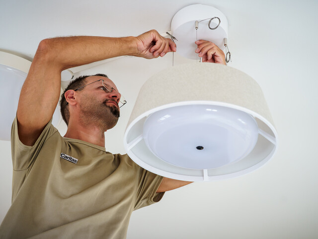 Haustechniker montiert smarte Nobi-Deckenlampe zur Sturzprävention im Haus Martha