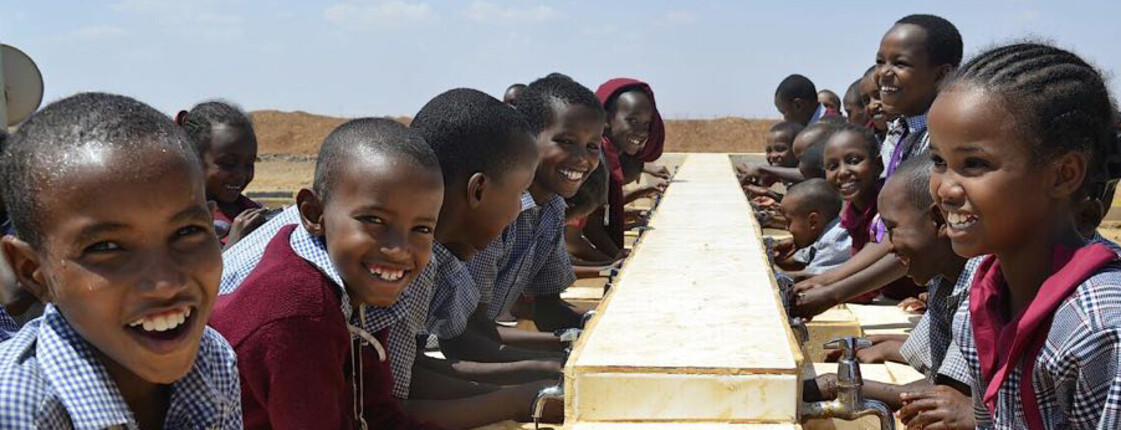 Die Kinder der Tiigo-School in Kenia waschen sich kollektiv an den Waschbecken, die Hände.