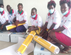 Junge Frauen, die mit ihren neuen Geldkassen für ein Gruppenfoto posieren.