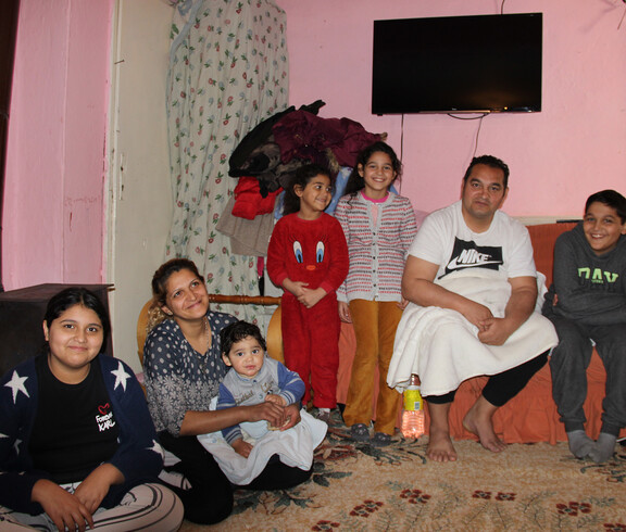 Die beiden Mädchen Joscha und Masche mit ihrer Mutter, ihrem Vater, ihren beiden Brüdern und ihrer Schwester im Wohnzimmer der Familie.