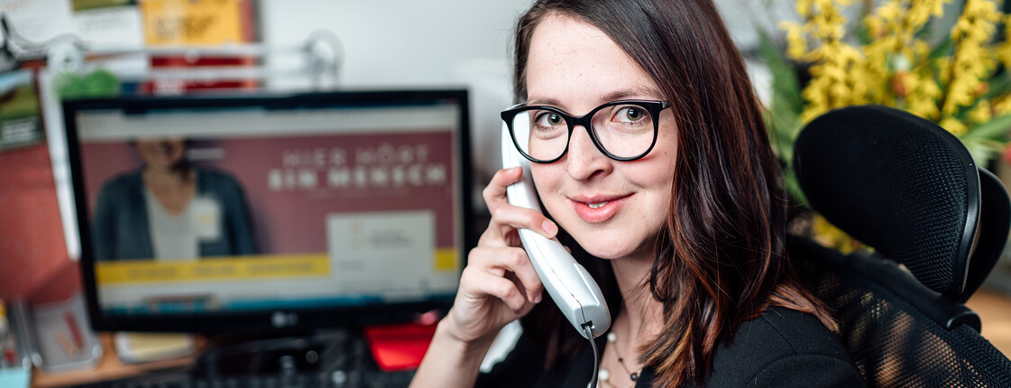Mitarbeitende der TelefonSeelsorge am Telefon im Büro; Unterstützung bei psychischen Krisen und Lebensberatung.