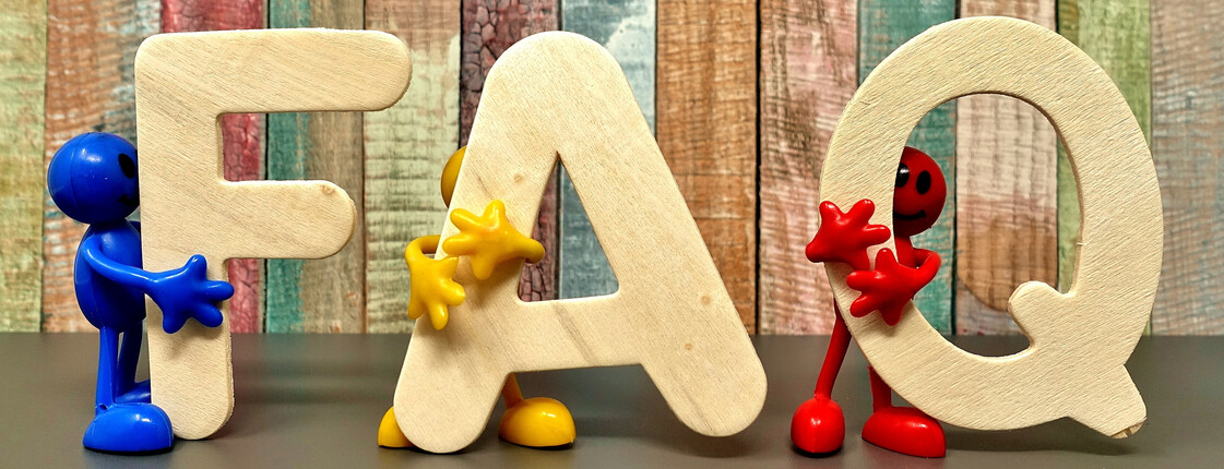 Die Buchstaben F, A und Q stehen vor einer bunten Wand. Jeder Buchstabe wird von einer Figur umarmt.