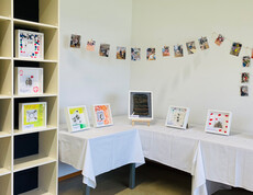 Gerahmte Kunstwerke und Fotos der Vernissage „Grenzenlos“ in der Werkstatt Florian.