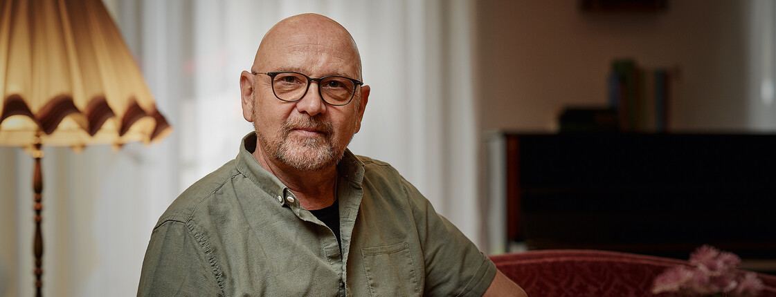 Einladung zum Vortrag "Persönliche Vorsorge: von der Patientenverfügung bis zum Testament" Älterer Mann mit Brille sitzt an Kaffeetisch.