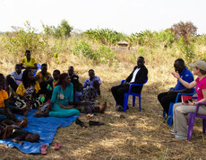 Die Mikrokredit-Spargruppe hat sich unter einem Baum versammelt und spricht mit unserer Projektreferentin Theresa Sacher.