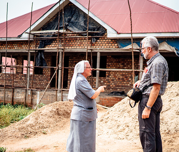 Eine Ordensschwester zeigt Diözesanbischof da neue Gebäude der Geburtenstation, das sich gerade im Bau befindet.