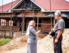Eine Ordensschwester zeigt Diözesanbischof da neue Gebäude der Geburtenstation, das sich gerade im Bau befindet.