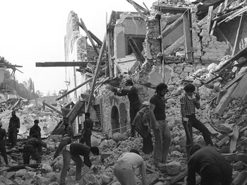 Menschen räumen Trümmer zwischen eingestürzten Gebäuden nach dem Erdbeben 1976 in Friaul, Schwarzweißaufnahme