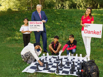 Kinder mit großem Schachspiel, Spendenscheck über 14.744 € für Caritas-Lerncafés übergeben.