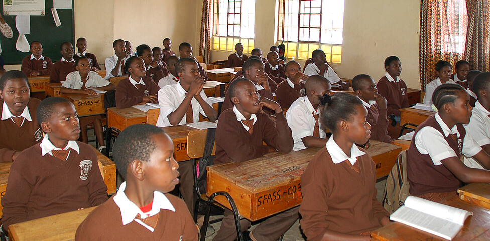 SchülerInnen der Secondary School sitzen in den Schulbänken und lernen für ihren Abschluss.