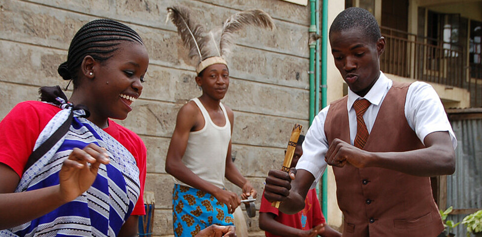 Kevin Obara tanzt mit einem Mädchen einen afrikanischen Tanz. Er durfte für den Papst spielen.