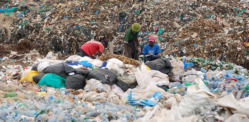 Menschen sammeln auf der Mülldeponie den verwertbaren Müll.