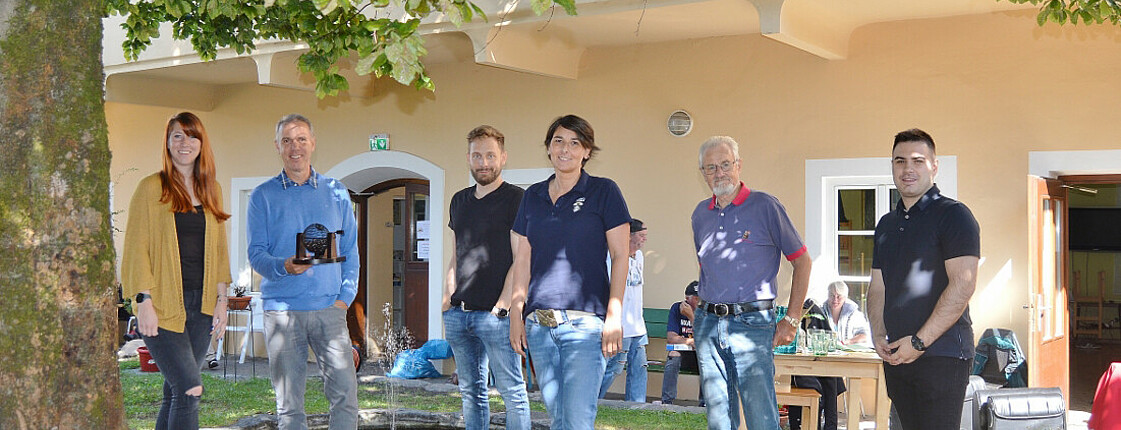 Eine Mitarbeiterin der Wohnungslosentagesstätte Eggerheim mit Freiwilligen eines Unternehmens bei der Führung durch die Einrichtung und anschließender Grillerei.
