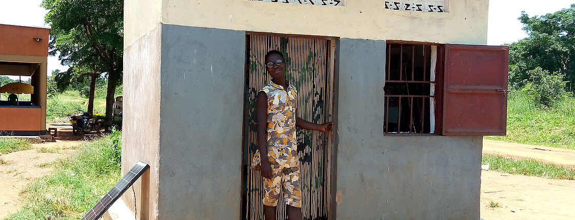 Ein junger Mann steht im Eingang seines eigenen kleinen Barber-Shops in Uganda.