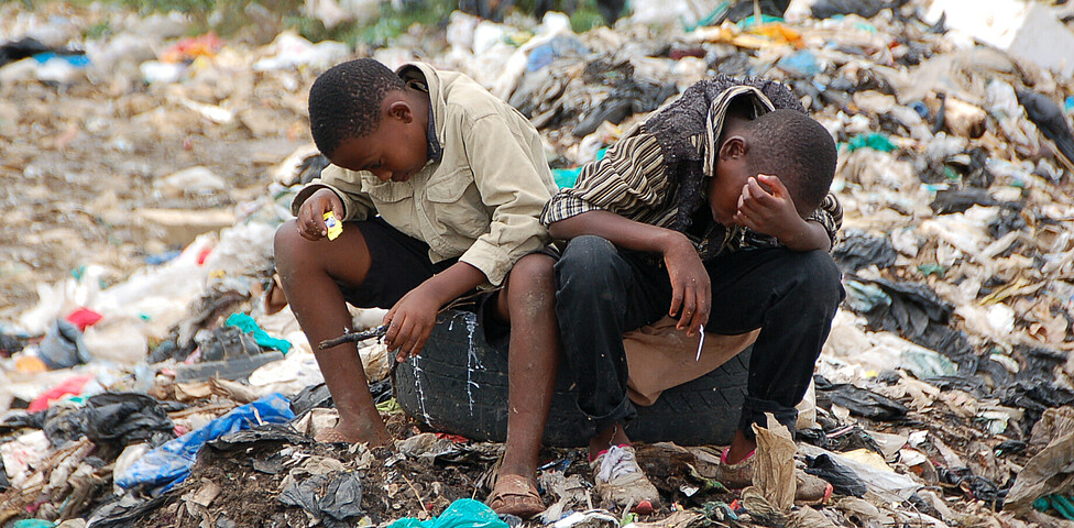 Zwei Kinder auf der Mülldeponie sammeln Müll