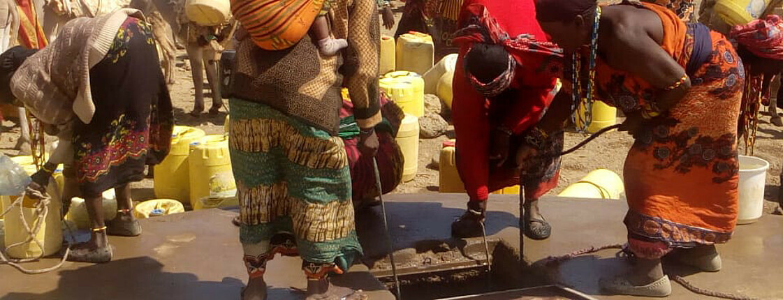Afrikaner*innen holen gemeinschaftlich Wasser aus den Tiefen Brunnen, während im Land eine Dürre herrscht.