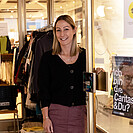 Die Shop-Leiterin in Villach bei der offenen Shop-Tür.